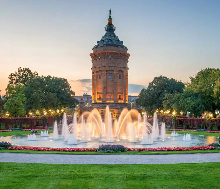 istorischer Wasserturm mit gro&szlig;em Springbrunnen und Parkanlage im Vordergrund