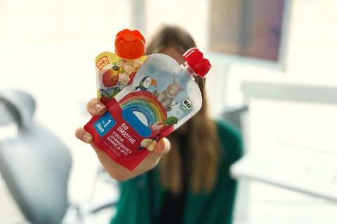 Frau hält zwei Quetschies in die Kamera